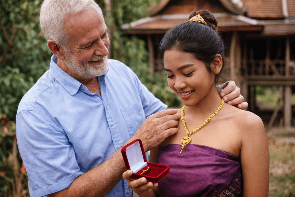 Older farang buying gift for thai girl